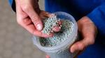 Unilever-wetenschapper met een handvol korrels gerecycled plastic