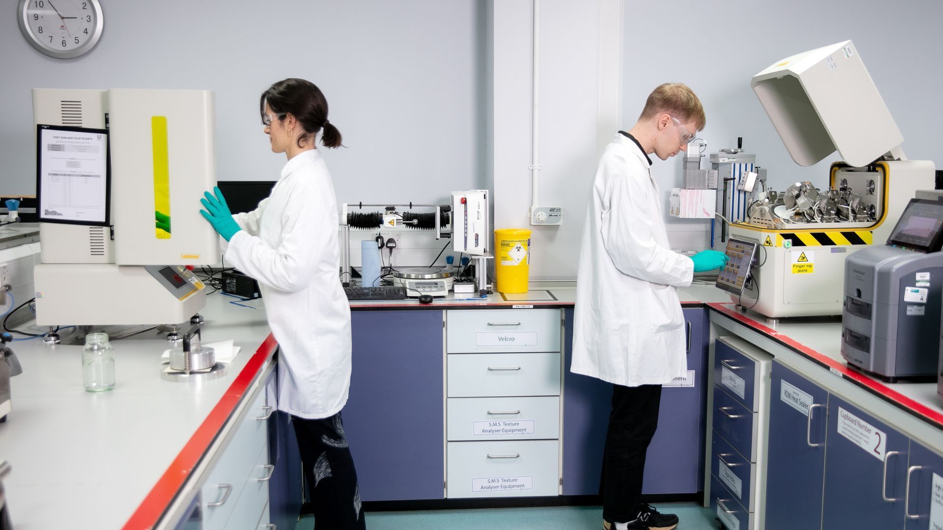 Twee wetenschappers op het gebied van Unilever-verpakkingsmateriaal testen monsters om hun barrière-eigenschappen tegen vocht, zuurstof en licht te controleren.